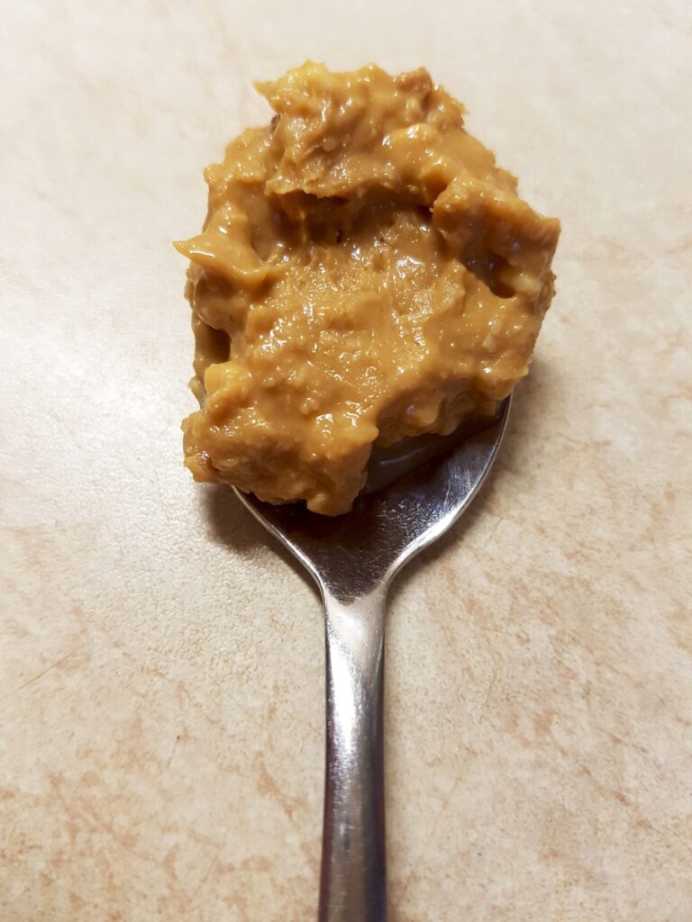 Spoonful of peanut butter on top of a flat horse lick mat surface