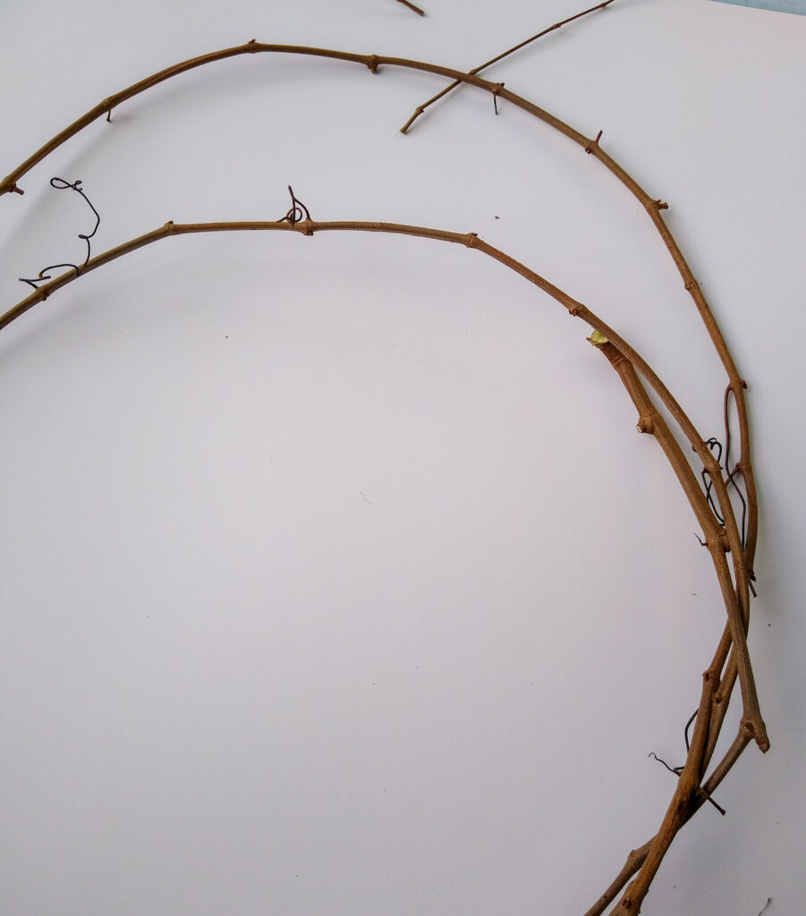 The grapevine edges are twisted around each other to make the frame of the DIY holiday horse wreath.