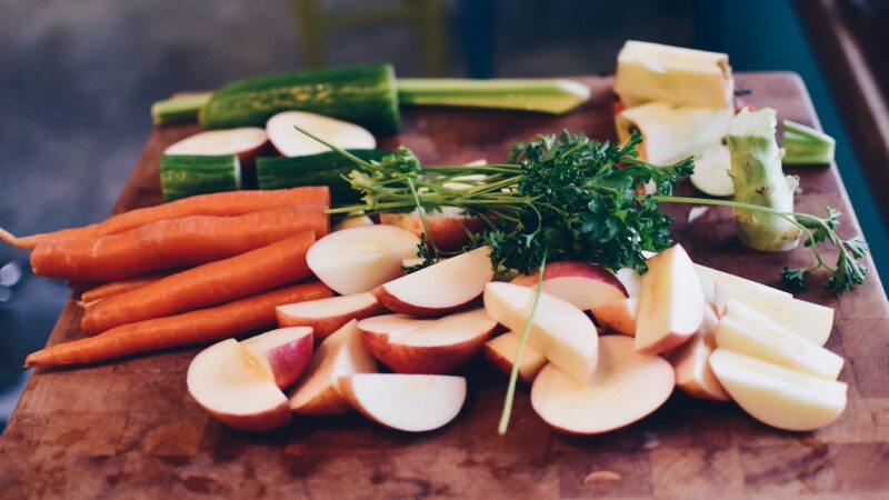 Mix of cut apples, carrots, cucumber, and herbs