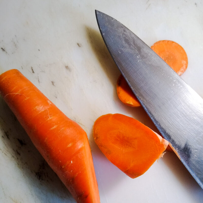 Close up of chef's knife and carrot slices