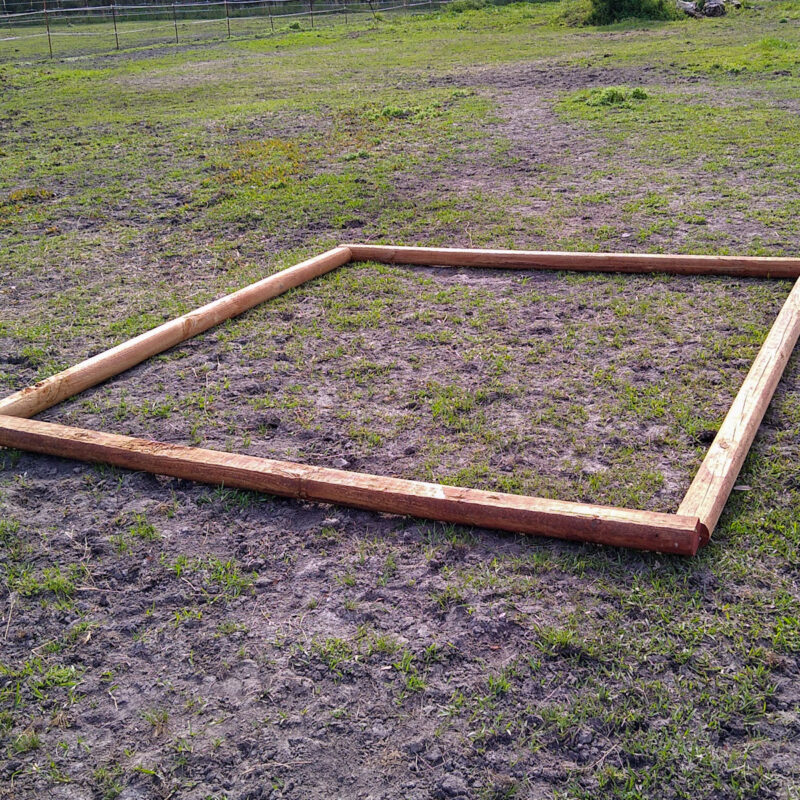 The timber frame outline of a DIY sand station for horses.