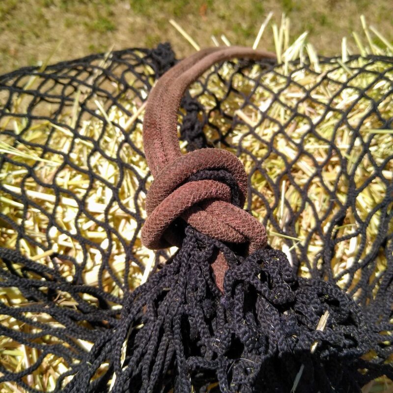 An overhand knot in the top of a hay net.