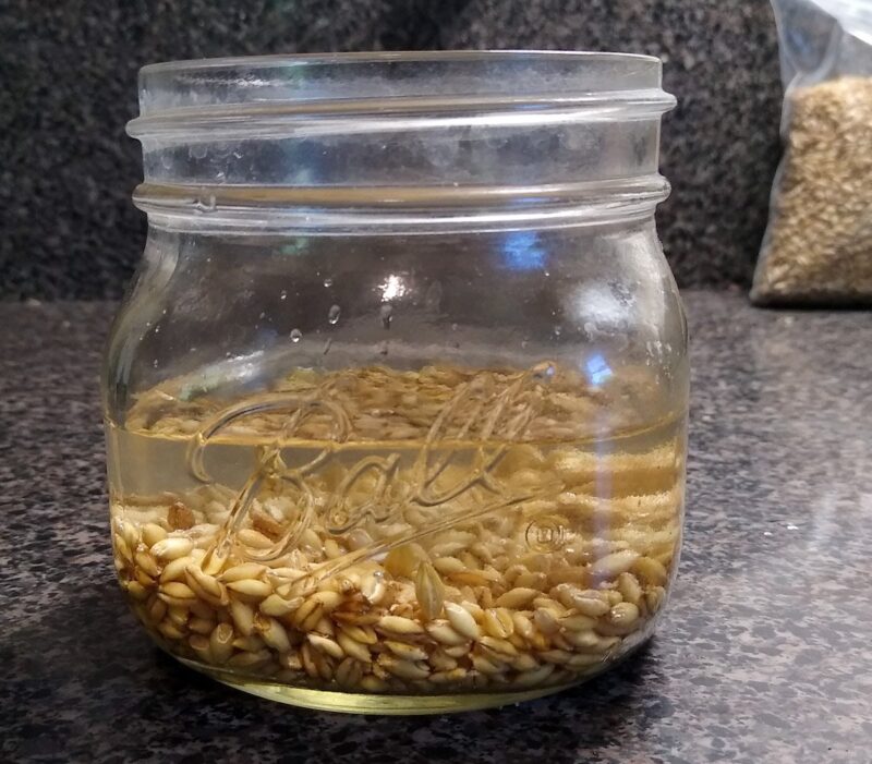 Close up of jar with oats soaking in water.