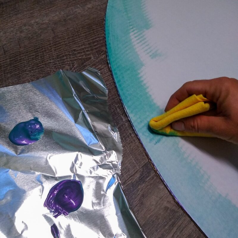 Painting the DIY treat board toy with nontoxic horse safe paint and a felt sponge.