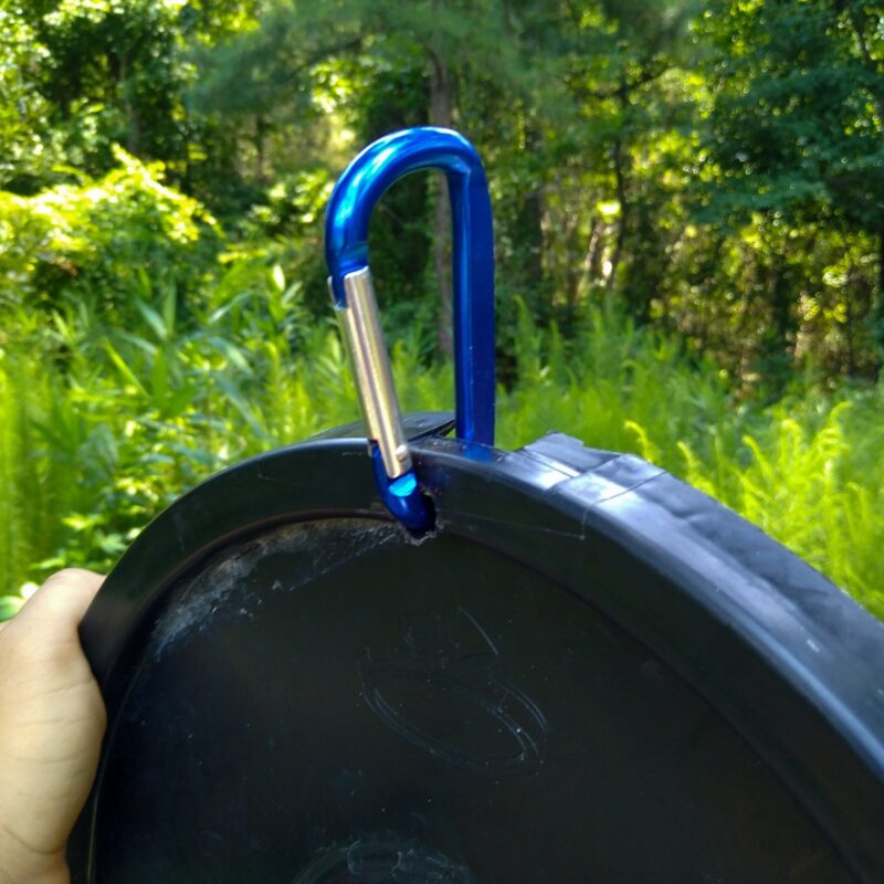 The bucket lid DIY horse toy enrichment gets a blue carabiner instead of a hook for increased safety with the horse.