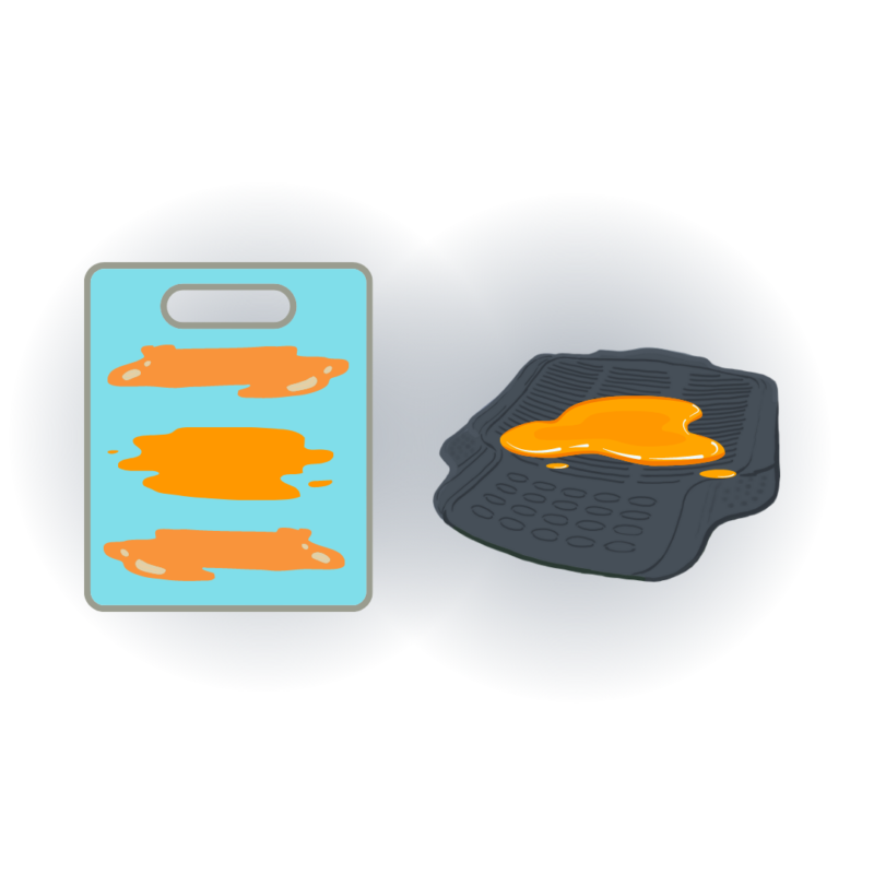 On the left, a cutting board with pureed pumpkin applied to surface. On the right, a textured rubber mat lying flat with pureed pumpkin applied to surface. 