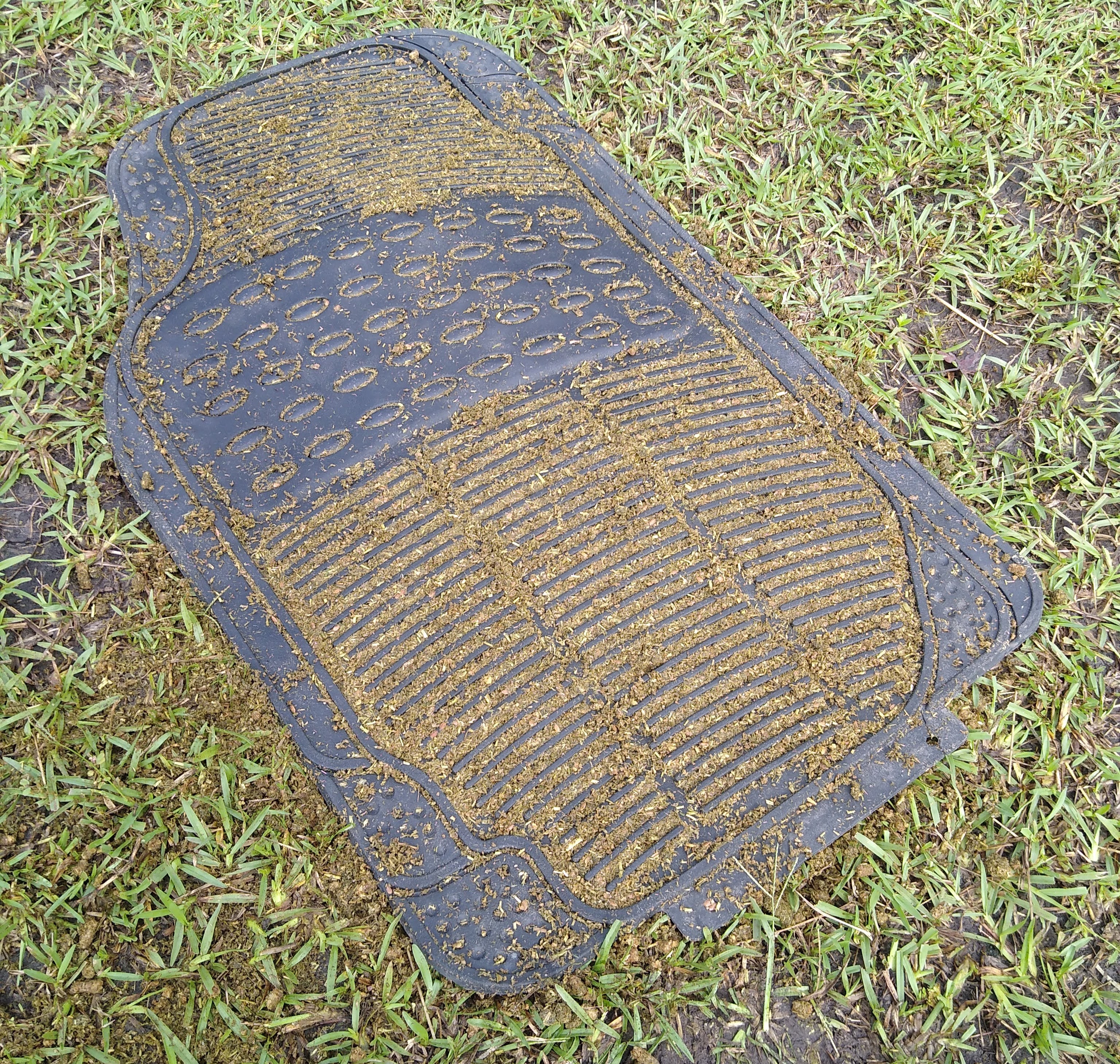 The DIY slow feeder mat for horses after a meal, showing leftover feed in the mat treads.