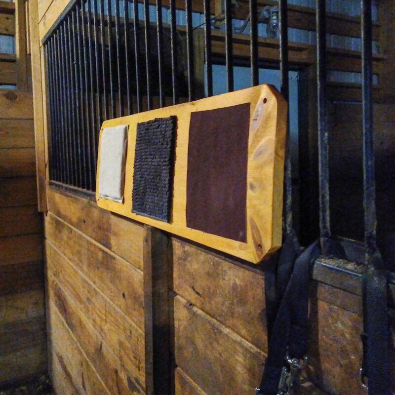 The textured sensory enrichment board on bars between horse stalls. 