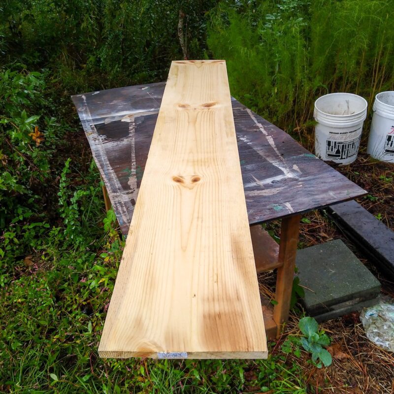 A pine wood board on a table before measuring to cut.