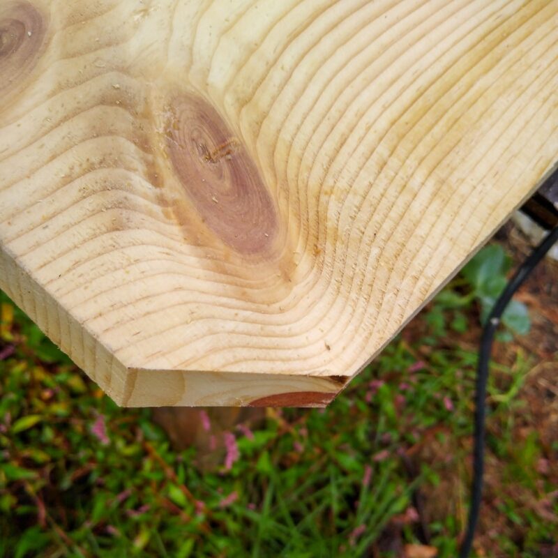 A close up view of the cut corners of the wooden sensory board showing sharp edges.