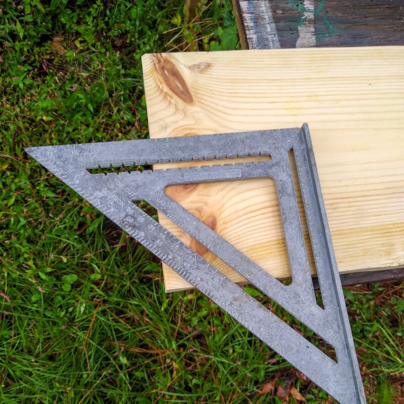 A carpenters square on the sensory enrichment board marking corners for cutting.