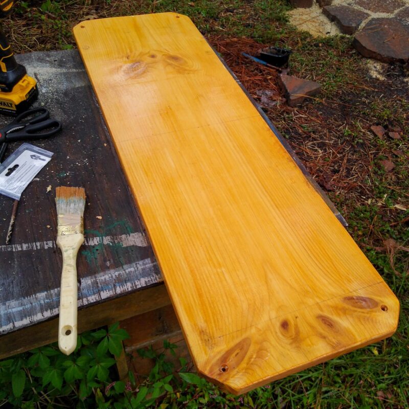 The stall enrichment board with coat of wood sealer and stain applied to create a cedar tone finish.