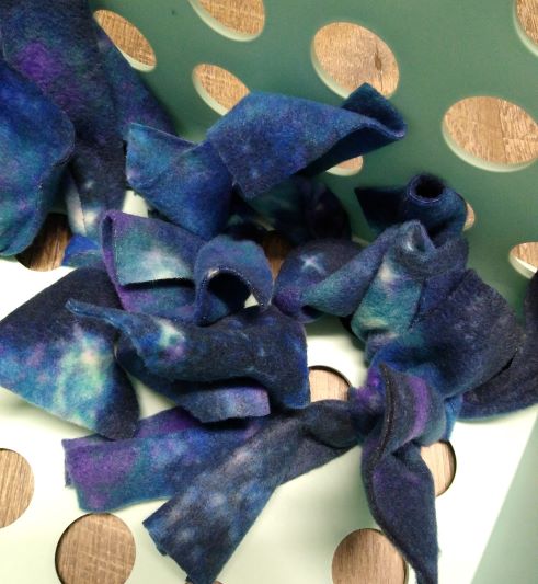 DIY horse snuffle box, close up of bottom fabric knots in blue fleece.