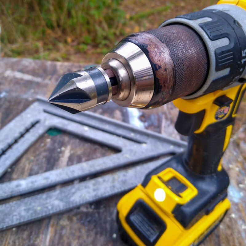 A black and yellow Dewalt cordless drill with countersink bit installed.
