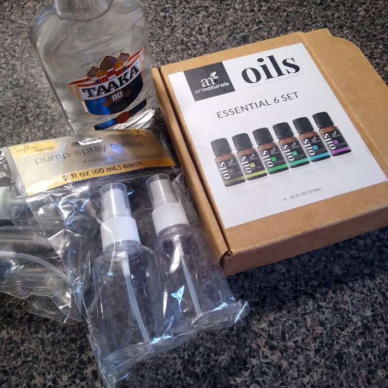 From left to right: bottle of vodka, cardboard box containing six essential oils, plastic packaging containing two pump sprayers. 