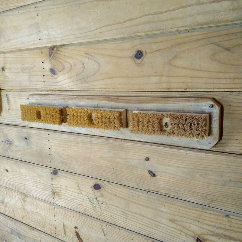 Scratching board for horses inside a horse stall.