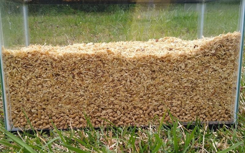 Wood shavings on top of a layer of wood pellets