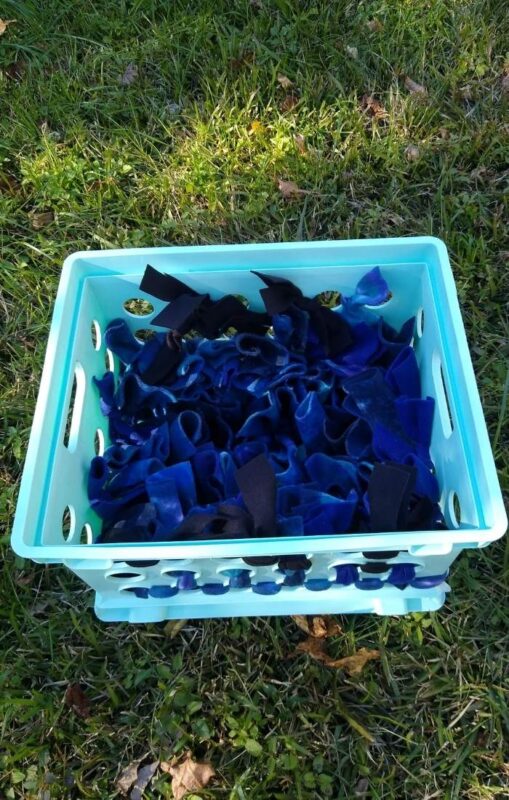 A DIY budget horse toy made from a blue plastic crate with fleece snuffle fabric.