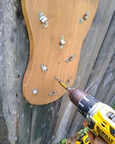 Installing a DIY browse board for horses against a solid wall using a Dewalt drill. 