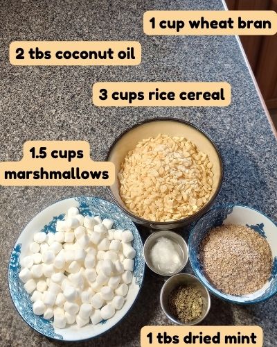 Bowls of ingredients for DIY stall snack licking treat for horses. Above bowls of ingredients, black text on yellow background reads: 1 cup wheat bran. 2 tbs coconut oil. 3 cups rice cereal. 1.5 cups marshmallows. 1 tbs dried mint. 