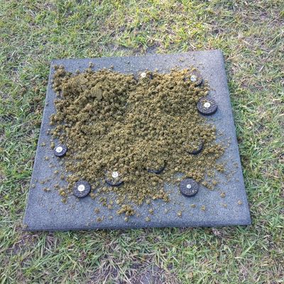 Completed DIY horse slow feed mat made from rubber stall mat pieces, with prepared horse feed