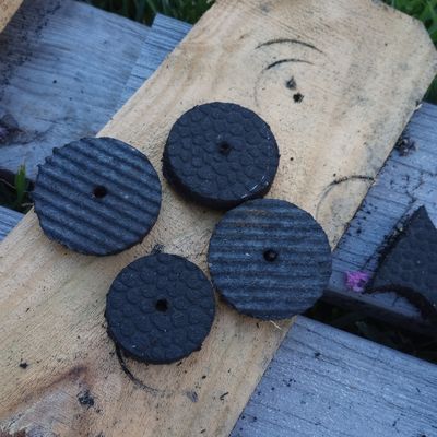 Circular pieces of black rubber from a hole saw used on a stall mat.