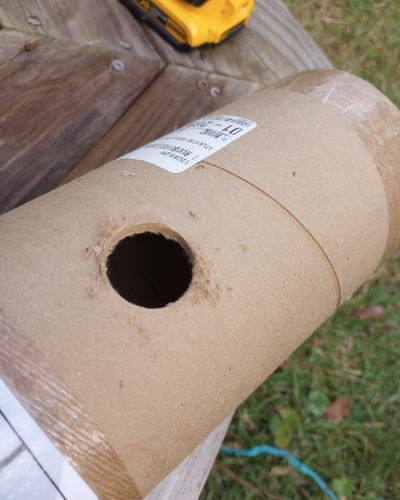 A clean round hole in a cardboard shipping tube.