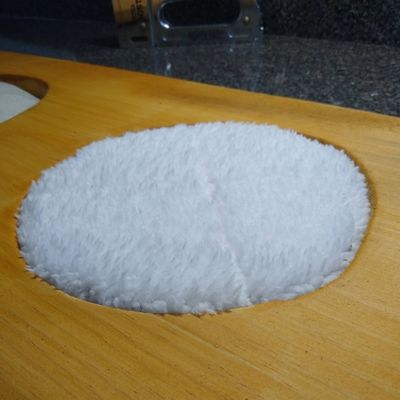 Close up of soft white fleece puff on DIY scent enrichment for horses project board.