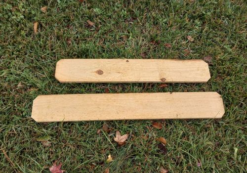 Two boards ready to be used for equine enrichment with rounded corners on a grass background.