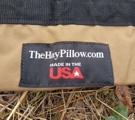 Brand tag shows black background with white text. Text reads TheHayPillow.com and beneath is red Made in USA symbol.