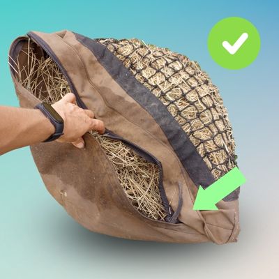 A hand closes up the Hay Pillow to make it easier to zip.
