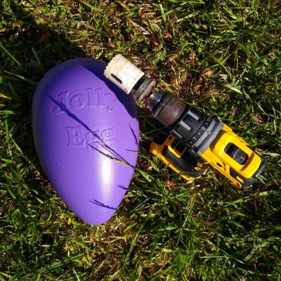 A Dewalt power drill next to a purple Jolly Egg for horse enrichment.
